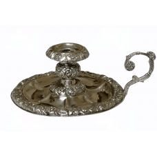 Artfully decorated metal candlestick with handle